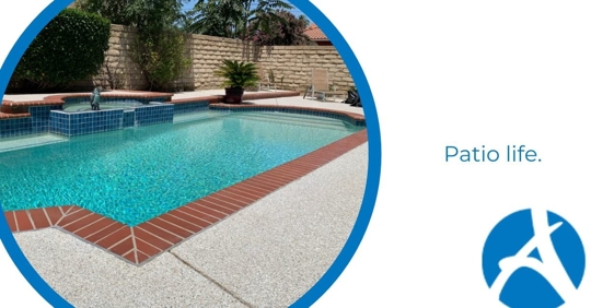 A corner of a pool with a concrete patio