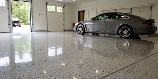 A car parked on a glossy garage floor, a result of a polyurea vs epoxy coating.