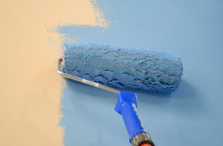 paint roller painting wall blue